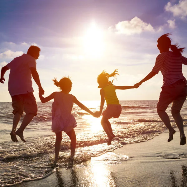 family jumping in air during sunset on the beach